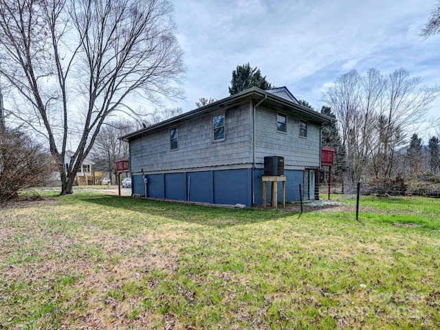 exterior space with central air condition unit and a lawn