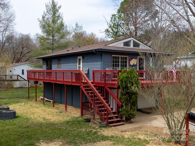 back of property featuring stairway, a lawn, a wooden deck, and a shingled roof