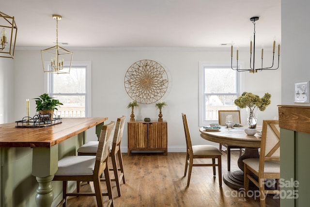 dining area featuring baseboards, ornamental molding, wood finished floors, and an inviting chandelier