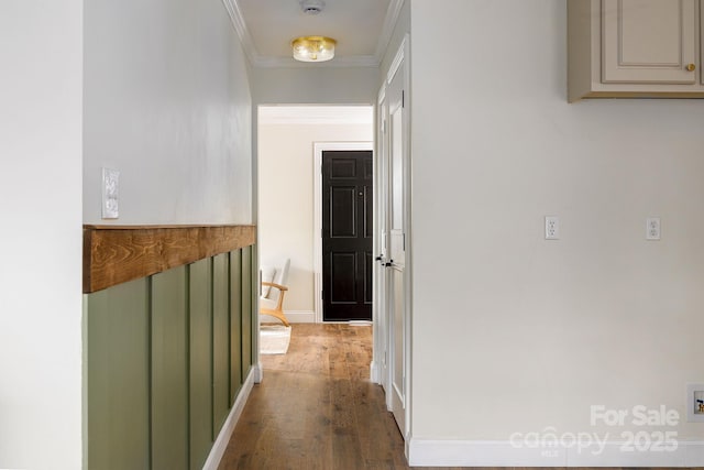 corridor featuring baseboards, ornamental molding, and wood finished floors