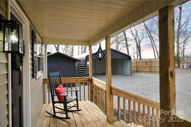 deck featuring an outdoor structure, a storage shed, and fence