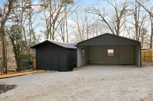 exterior space with a carport, a shed, gravel driveway, and fence