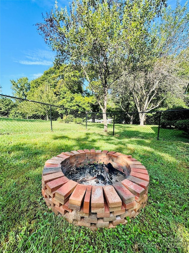 view of yard with an outdoor fire pit and fence