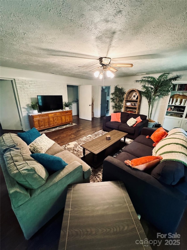 living area featuring a textured ceiling, wood finished floors, and a ceiling fan