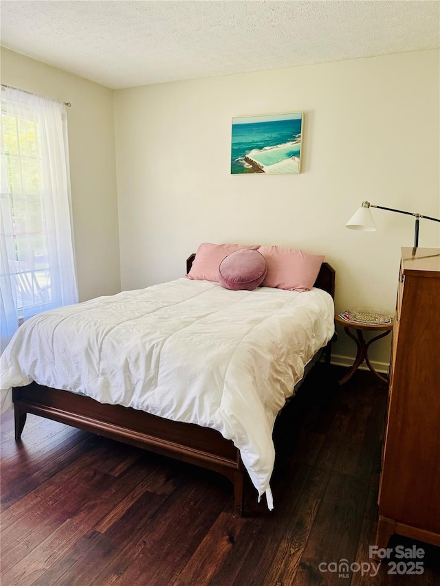 bedroom featuring a textured ceiling and wood finished floors