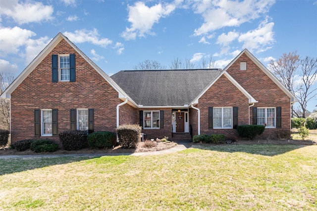 traditional-style house featuring brick siding, a front lawn, and a shingled roof