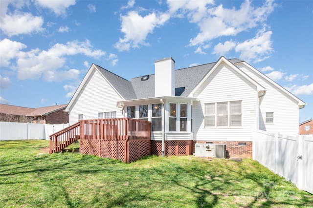 rear view of house with a lawn, a fenced backyard, roof with shingles, a sunroom, and a wooden deck