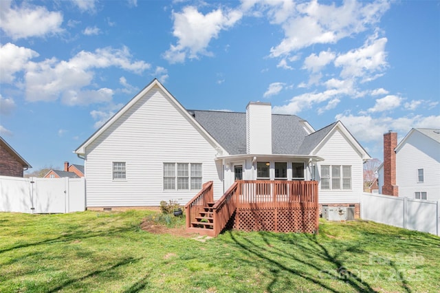 back of house featuring crawl space, a yard, a fenced backyard, and a gate