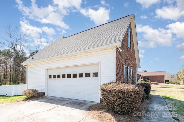 view of property exterior featuring brick siding, driveway, a shingled roof, and fence