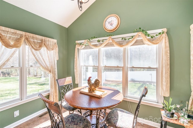 dining area with visible vents, baseboards, and vaulted ceiling