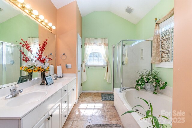 full bath with double vanity, a stall shower, lofted ceiling, and a sink