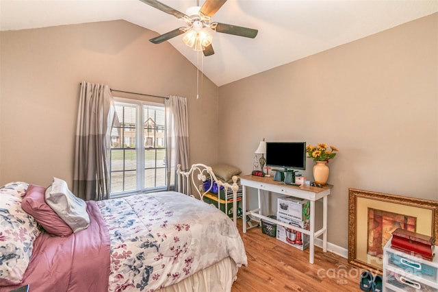 bedroom featuring a ceiling fan, lofted ceiling, wood finished floors, and baseboards