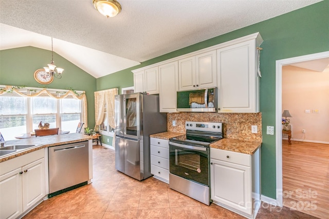 kitchen with a sink, appliances with stainless steel finishes, and white cabinets