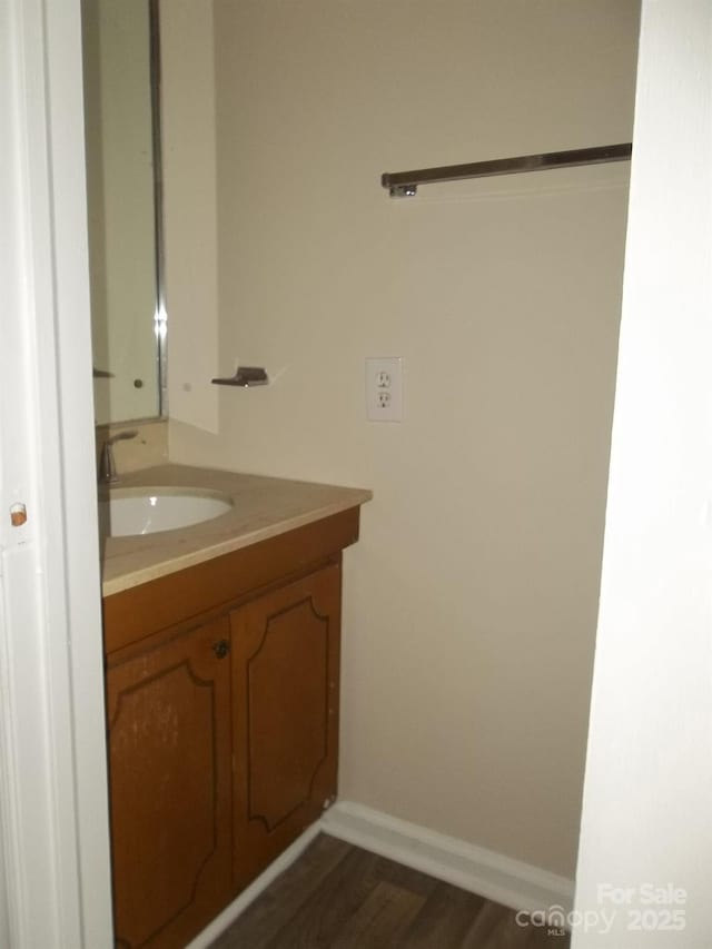 bathroom featuring vanity, baseboards, and wood finished floors