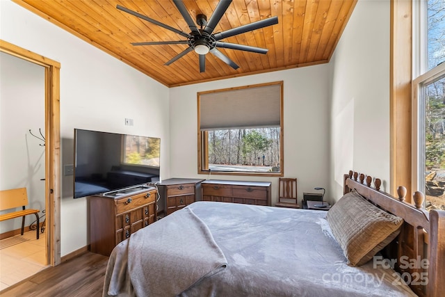 bedroom featuring multiple windows, wood ceiling, baseboards, and wood finished floors