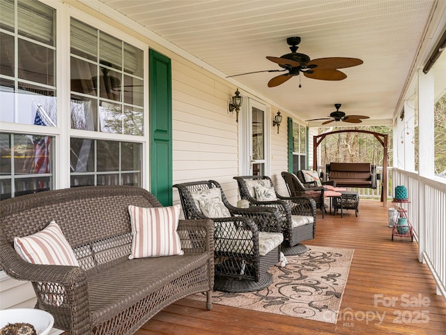 deck with an outdoor living space, covered porch, and a ceiling fan