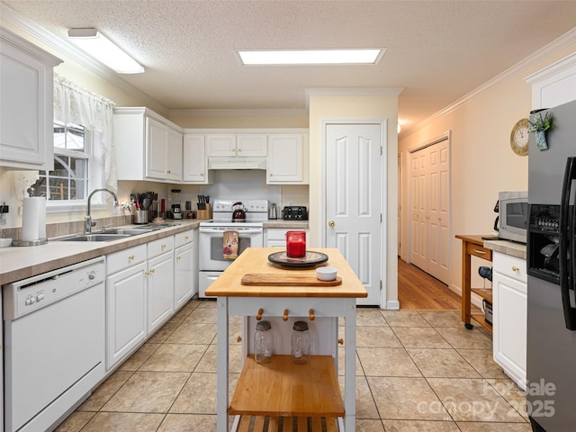 kitchen with ornamental molding, a sink, under cabinet range hood, white cabinetry, and stainless steel appliances