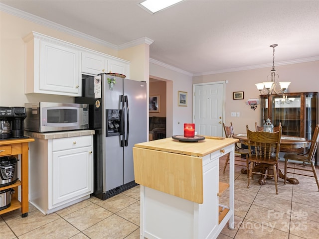 kitchen with butcher block countertops, an inviting chandelier, appliances with stainless steel finishes, and white cabinetry