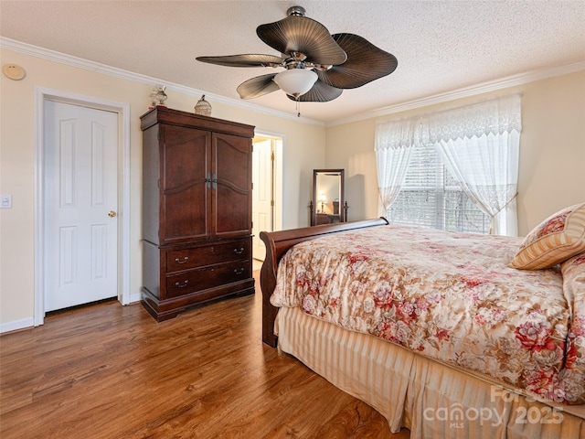 bedroom featuring crown molding, wood finished floors, and a textured ceiling