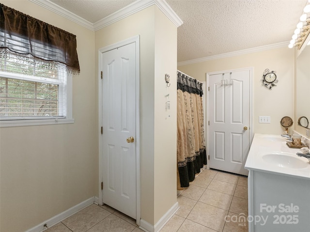 bathroom with a sink, a textured ceiling, crown molding, and tile patterned flooring