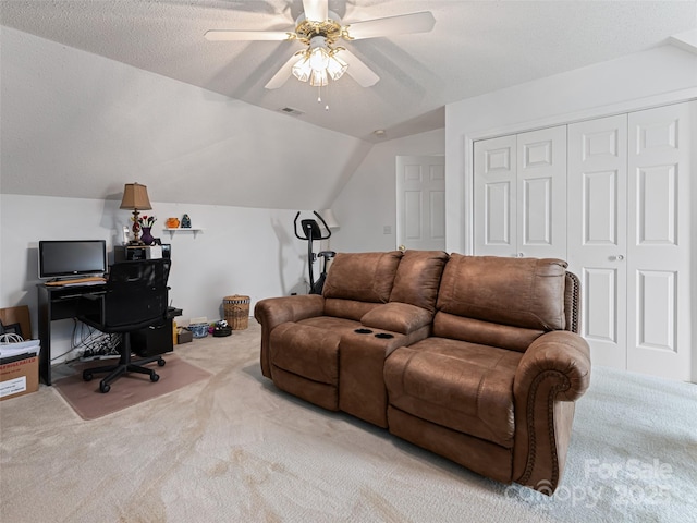 living area with a ceiling fan, lofted ceiling, light colored carpet, and a textured ceiling