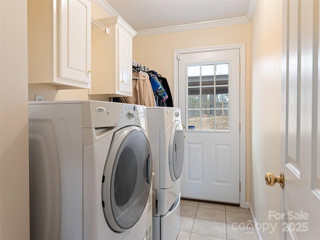 laundry room with crown molding, light tile patterned floors, cabinet space, a textured ceiling, and separate washer and dryer