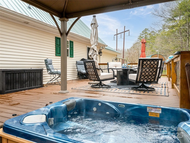 deck with a gazebo, hot tub deck surround, and outdoor dining space