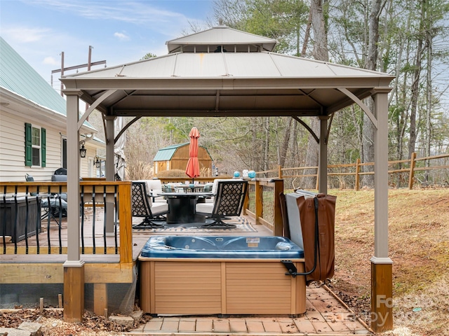 deck with a gazebo, a hot tub, outdoor dining area, and fence