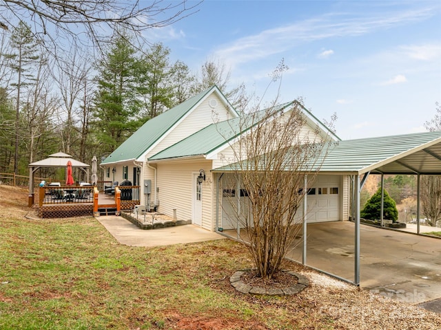 view of front of house featuring a wooden deck, a front yard, metal roof, a garage, and driveway