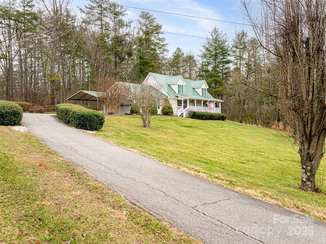 view of front facade featuring aphalt driveway, covered porch, and a front yard