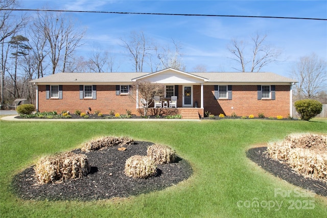 ranch-style home featuring a porch, brick siding, and a front yard