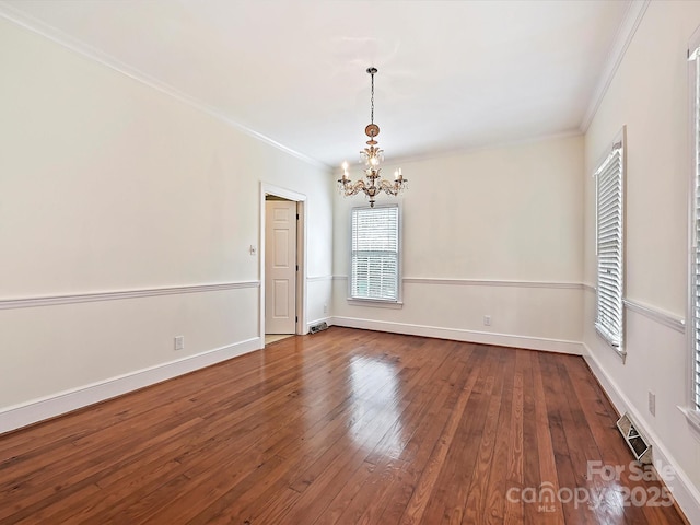 empty room with dark wood-style flooring, crown molding, and baseboards