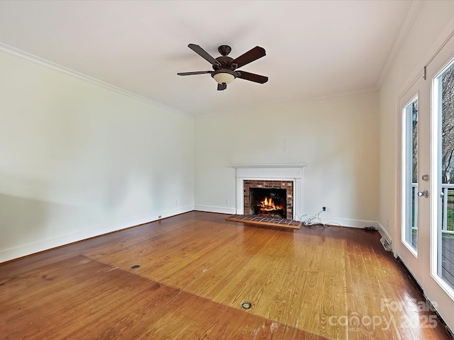 unfurnished living room with baseboards, a fireplace, ornamental molding, and wood finished floors