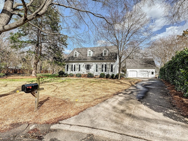 cape cod-style house featuring a garage, a front lawn, and an outdoor structure