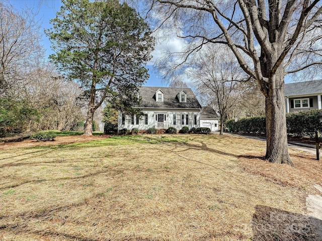 cape cod house with a garage and a front yard