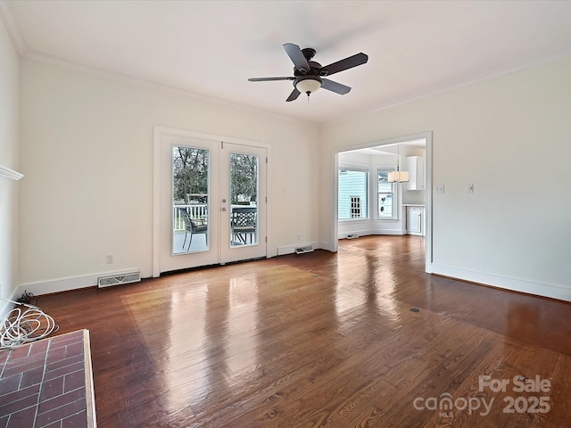 unfurnished living room with baseboards, visible vents, wood finished floors, and ornamental molding