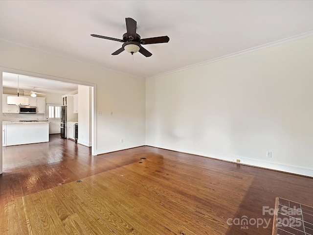 unfurnished living room with crown molding, dark wood finished floors, baseboards, and ceiling fan