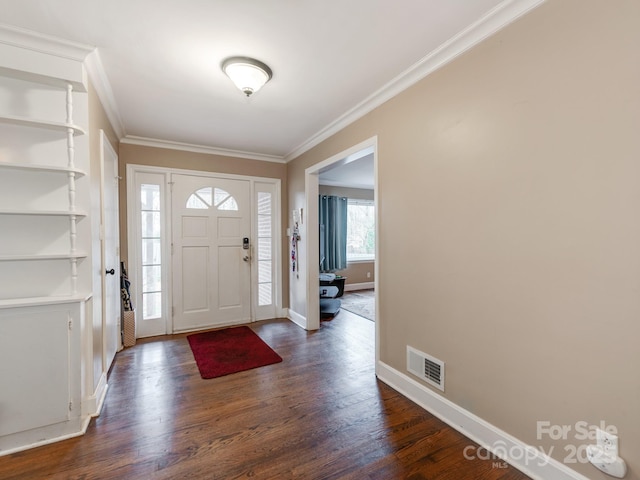 foyer featuring crown molding, dark wood finished floors, visible vents, and baseboards