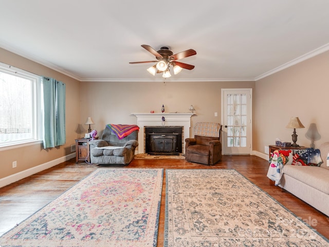 living area featuring baseboards, ornamental molding, and wood finished floors