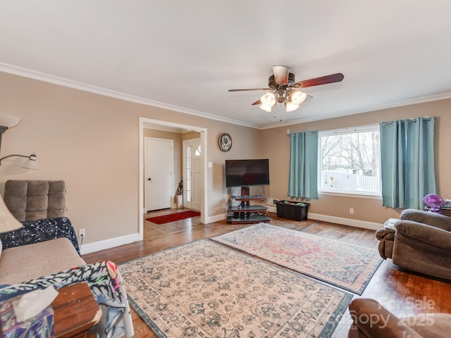 living area with ceiling fan, crown molding, baseboards, and wood finished floors