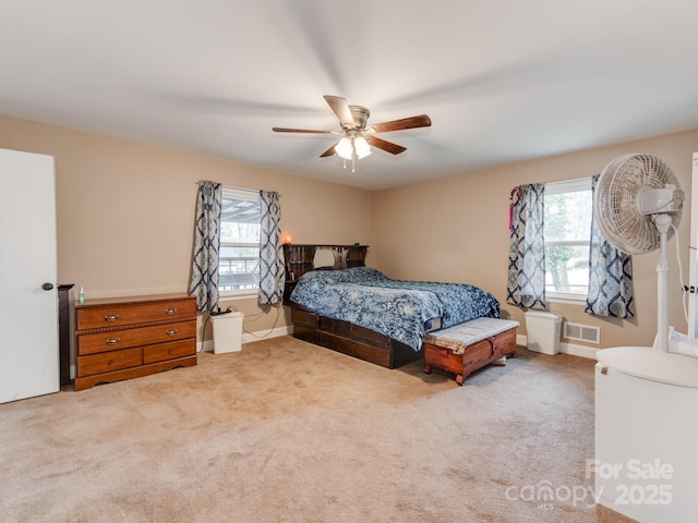 bedroom featuring ceiling fan, multiple windows, carpet flooring, and visible vents