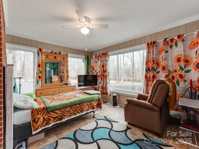 living room with ceiling fan and a textured ceiling