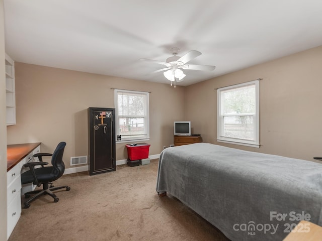 carpeted bedroom with baseboards, visible vents, and a ceiling fan