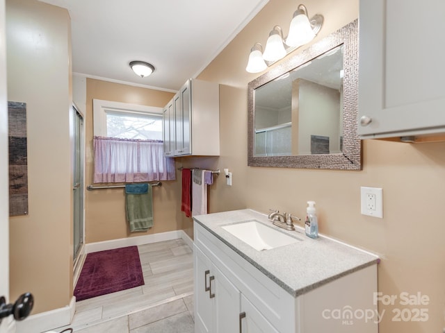 full bathroom featuring wood tiled floor, baseboards, a shower stall, and vanity