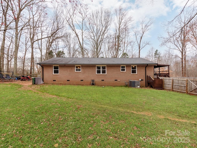 rear view of house featuring crawl space, brick siding, a yard, and central air condition unit