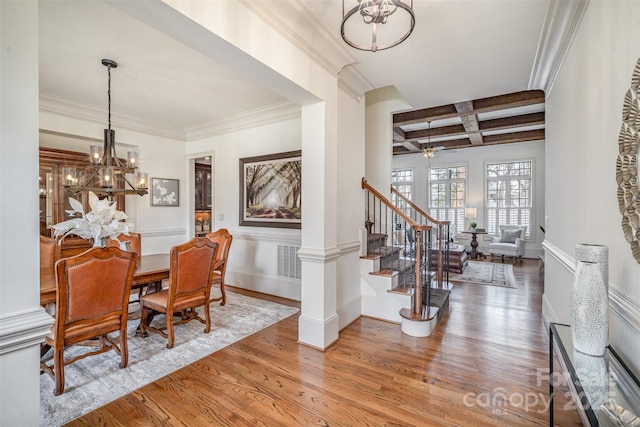 dining space featuring beamed ceiling, stairway, an inviting chandelier, wood finished floors, and coffered ceiling