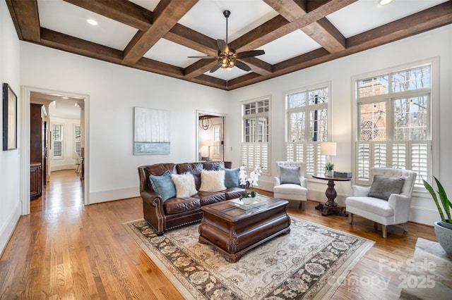 living area featuring coffered ceiling, ceiling fan, and light wood finished floors