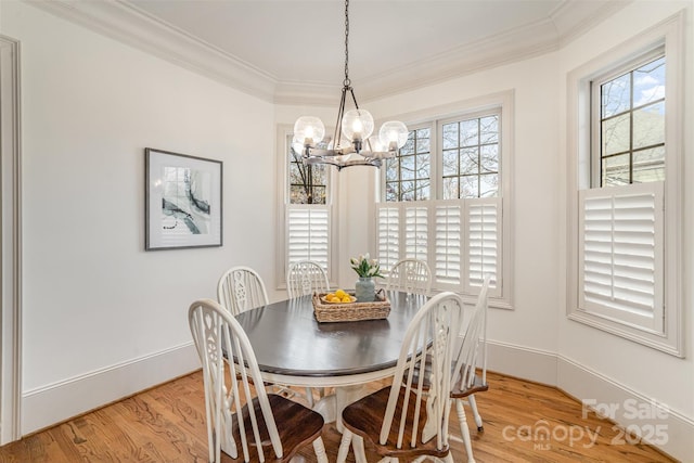 dining area with a notable chandelier, baseboards, light wood finished floors, and ornamental molding