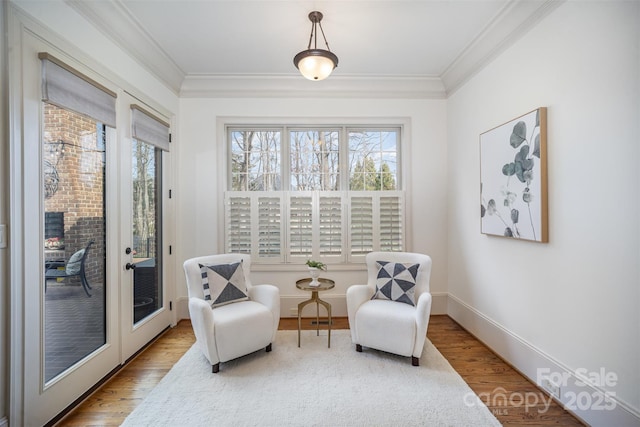 sitting room featuring a wealth of natural light, wood finished floors, and ornamental molding