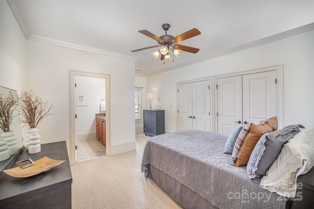 bedroom featuring two closets, ensuite bathroom, light colored carpet, and crown molding